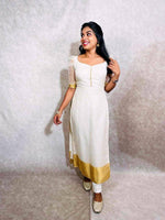 Load image into Gallery viewer, White Kurti features Soft Organza Fabric with check patterns and a Zari border. It has a pan neck, puff half sleeves, and a 44-inch length. Easy to maintain with machine wash. Comes as a single kurti piece.