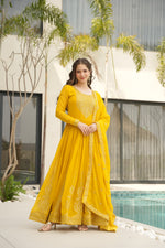 Load image into Gallery viewer, Yellow embroidered gown with designer dupatta , Faux blooming yellow gown for haldi ceremony , Elegant yellow gown with sequin work , Yellow round neck ethnic gown for women , Bright yellow party wear gown with dupatta , Yellow long gown with lace border details , Yellow full sleeve gown for traditional functions , Soft cotton-lined yellow gown for comfort , Yellow color gown with zari embroidery .