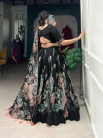 Load image into Gallery viewer, Black Tussar silk lehenga with floral print and lace detailing , Elegant black floral lehenga with heavy tassels and can-can flair , Black lehenga choli set in printed Tussar silk with gotta patti dupatta , 
Traditional black lehenga with canvas stitching and zip closure . 
