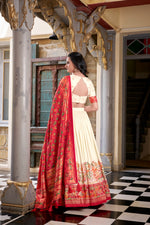 Load image into Gallery viewer, Elegant Cream with Red Color  Tussar Silk Dhavani Set featuring a stitched lehenga with foil prints (waist up to 42&quot;, length 41&quot;), unstitched blouse piece (0.80m), and decorated dupatta (2.4m) with Gotta Patti border and tassels. Complete three-piece ensemble with premium finishes.
