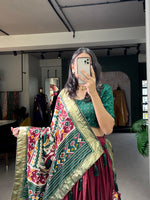Load image into Gallery viewer, Dark maroon Tussar silk dhavani featuring patola print with foil work. Set includes stitched lehenga (42&quot; length, fits waist up to 42&quot;), unstitched blouse (0.80m), and decorated dupatta (2.5m) with gotta patti Border tussar Silk Lehenga Price Under 2000 . 

