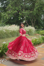 Load image into Gallery viewer, Rani Pink Rangoli Silk Half Saree features a fully stitched lehenga made from Rangoli Silk with heavy sequins and thread embroidery, measuring 42&quot; in length and waist, with a 3.5-meter flair and zip closure with dori latkan. The blouse fabric is unstitched Rangoli Silk with matching embroidery, and the dupatta is 2.2 meters long with a designer lace border .
