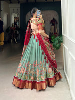Load image into Gallery viewer, Dola Silk Dhavani Set featuring Kalamkari printed lehenga with zari border, matching unstitched blouse, and tasseled dupatta. Stitched lehenga includes drawstring closure and micro cotton inner lining for comfort.

