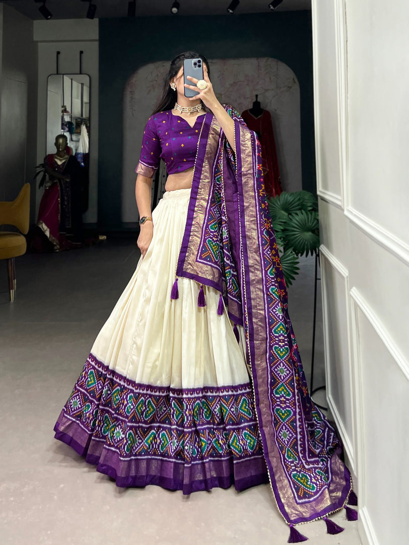 Stun in a gorgeous Tussar Silk Floral Lehenga Set! Featuring a stitched lehenga with can-can, a Patola print dupatta with tassels, and an unstitched blouse, this ensemble exudes elegance for any festive occasion.