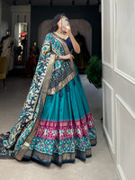 Load image into Gallery viewer, Tussar silk dhavani ensemble featuring patola print with foil accents. Includes stitched lehenga with unstitched blouse, and decorated dupatta with gotta patti border. Traditional craftsmanship with modern comfort features - Shop Now Shoppers Trend

