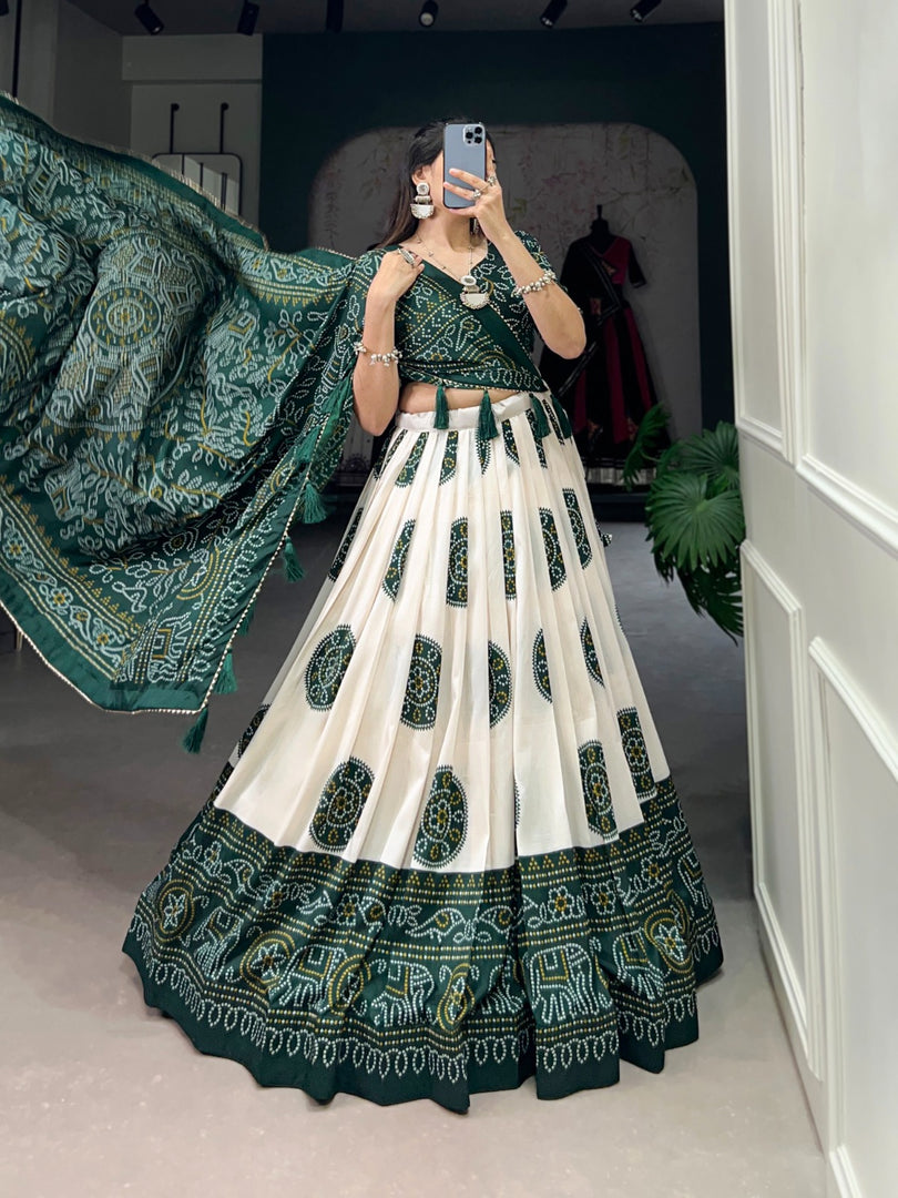 Green Bandhani print lehenga with drawstring and zip , Elegant partywear green lehenga with zari border details , Stylish green lehenga with tassels and floral bandhani print , Indian wedding green lehenga with traditional design . 