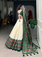 Load image into Gallery viewer, Traditional Green Tussar Silk Lehenga with Patola Print Blouse , 
Stunning Green Lehenga with tassel accents and Gotta Patti lace , Green Patola Lehenga with elegant silk fabric , Designer Green Lehenga for weddings and festivals .
