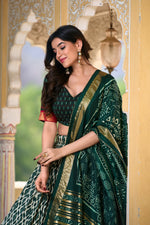 Load image into Gallery viewer, Green tussar silk lehenga with foil ikkat print and tassels , Traditional green lehenga with gotta patti lace dupatta , Designer green lehenga choli set in rich tussar silk , Festive green ikkat print lehenga with foil detailing . 

