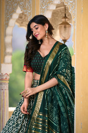 Green tussar silk lehenga with foil ikkat print and tassels , Traditional green lehenga with gotta patti lace dupatta , Designer green lehenga choli set in rich tussar silk , Festive green ikkat print lehenga with foil detailing . 