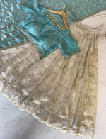 Load image into Gallery viewer, Premium Light Sky tissue silk half-saree set featuring gold zari lehanga (3.5m stitched), embroidered blouse material (0.8m unstitched), and decorative voni (2.3m) with intricate cut work border.
