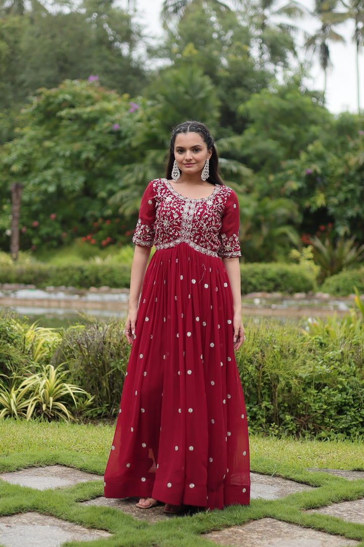 Elegant maroon gown with zari and sequin finish , Bridal maroon gown in faux blooming fabric , Half sleeve maroon gown with cotton inner , Rich maroon embroidered gown for party looks , 3.5 mtr flair gown in traditional maroon tone , Designer maroon gown for sangeet and wedding . 