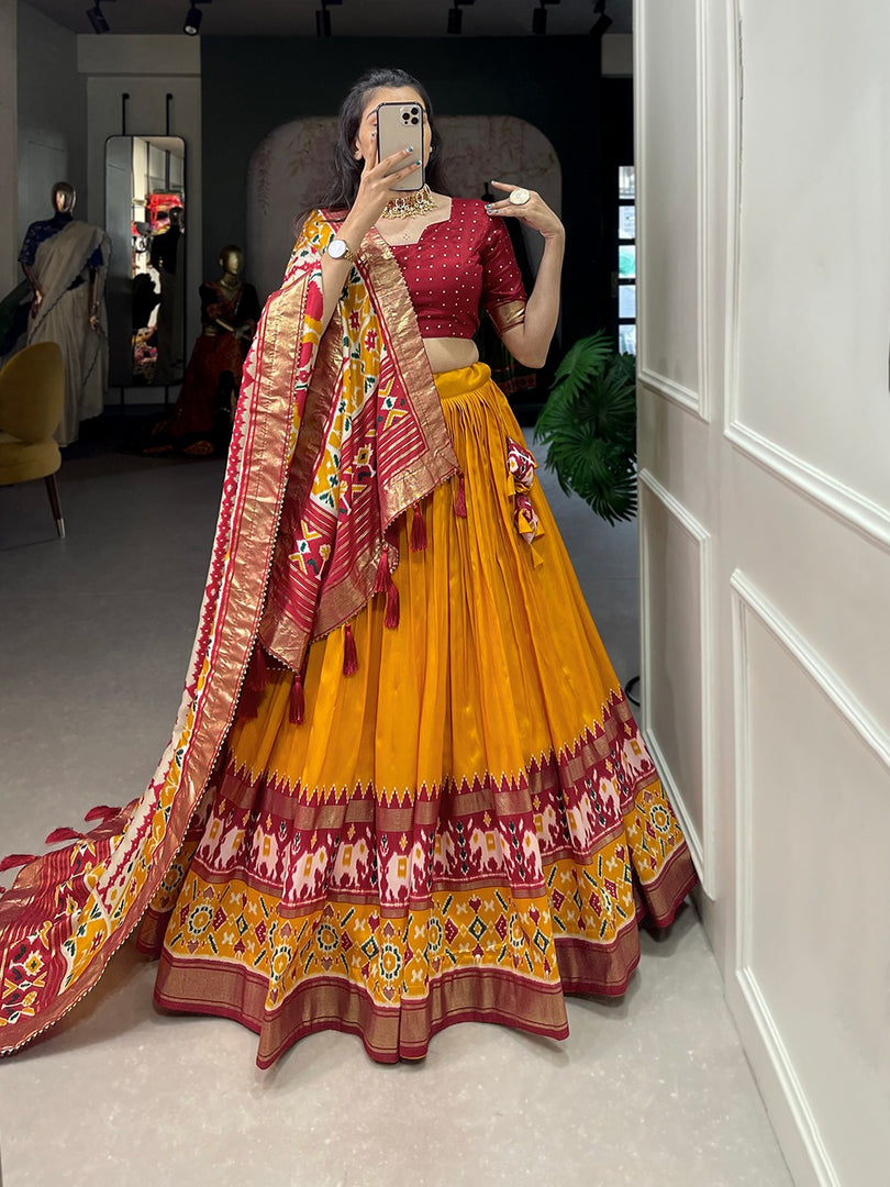 Tussar silk dhavani with patola print and foil detailing. Set includes stitched lehenga (42" waist max), unstitched blouse, and decorated dupatta with gotta patti border. Features can-can structure and micro cotton lining for comfort and enhanced silhouette.