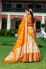 Load image into Gallery viewer, Bright Orange Dola Silk Lehenga with Shibori print , Orange Zari Border Lehenga – Perfect for Haldi or Mehndi , Festive Orange Lehenga with tassel dupatta , Traditional Orange Lehenga in Shibori design . 
