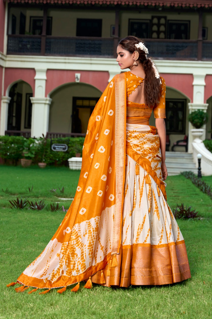 Bright Orange Dola Silk Lehenga with Shibori print , Orange Zari Border Lehenga – Perfect for Haldi or Mehndi , Festive Orange Lehenga with tassel dupatta , Traditional Orange Lehenga in Shibori design . 