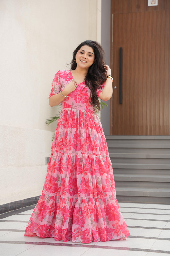 Elegant pink gown in printed faux georgette , Pink color gown with beautiful floral design , Floor-length pink gown with full 12-meter flair , Designer pink ethnic gown for festive wear , Soft pink gown with V-neck and half sleeves .