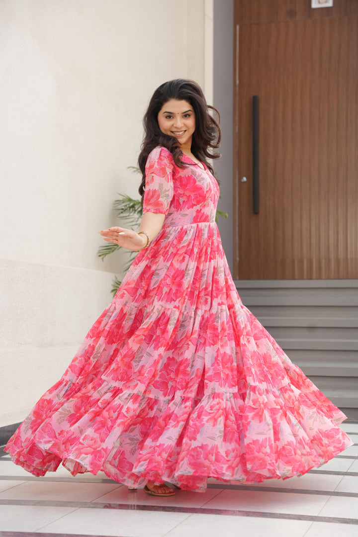 Peach or Pink Color Printed faux georgette gown with 56" length, 12-meter flair, and full cotton lining. Features half sleeves and fancy V-neck. One complete stitched gown included.