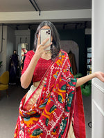 Load image into Gallery viewer, Exquisite Siya Tussar Silk Dhavani featuring patola print with foil work. Includes stitched lehenga ( 3.80m flair) with drawstring, tassels and can-can, unstitched tussar silk blouse (0.80m), and tussar silk dupatta (2.5m) adorned with gotta patti lace border and tassels. Crafted with premium micro cotton inner lining for comfort.


