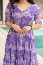 Load image into Gallery viewer, Purple Color Printed faux georgette gown with cotton lining. 56&quot; long with 12m flair. Half sleeves, V-neck. Fully stitched Gown price under 1499 .

