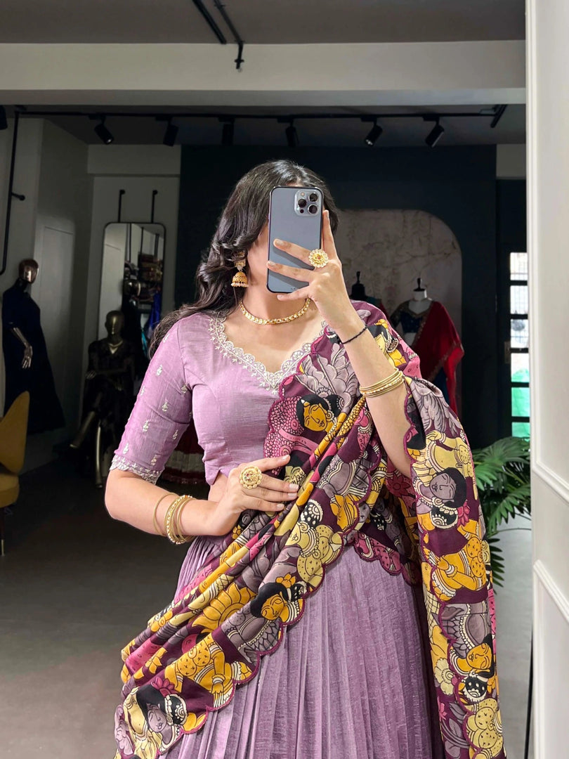Upgrade your wardrobe with this high-quality, designer half-saree set. Made from luxurious Vichitra Silk, the Lehenga features stunning sequins and thread embroidery work with a striking Kalamkari print border. The complementary Tussar Silk Dupatta adds an elegant touch with its Kalamkari print and foil work, complete with a delicate scallop border. With 4 meters of luxurious flair, the Lehenga is sure to make a statement