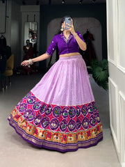 Purple Pre-stitched Tussar Silk Dhavani with Bandhej and Patola print. Features adjustable waist , 3.80m flair, and mirror-worked cotton blouse. Complete set includes lehenga, blouse, and all accessories.

