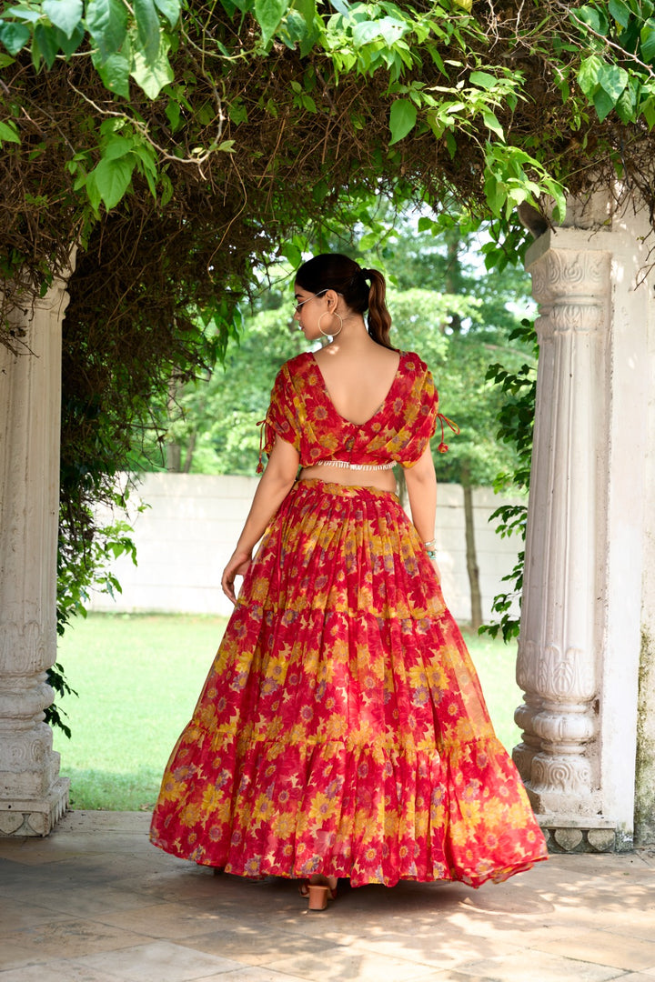 Bold red chiffon lehenga with floral print and pearl accents , Traditional red lehenga for weddings, receptions, and festivals , Red floral lehenga with stitched blouse and 9-meter flair , Shop elegant red lehenga with zipper and drawstring waist , Beautiful red lehenga with printed blouse for bridal events.