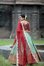 Load image into Gallery viewer, Classic red Kanjivaram lehenga with full-stitched canvas and cancan , Pure pattu silk red lehenga with handcrafted zari work , Gorgeous red lehenga set with dola silk blouse and cutwork dupatta , 
Celebrate in style with this heavy red bridal lehenga . 
