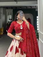 Load image into Gallery viewer, Bright red Bandhej lehenga in luxurious tussar silk , Red bridal wear lehenga with Bandhej print and lace border , Festive red color lehenga with handmade tassels and flair , Designer red Tussar silk lehenga for wedding occasions.
