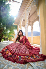 Load image into Gallery viewer, Red tussar silk lehenga with ikkat foil print for bridal functions , Elegant red lehenga choli with handcrafted tassels and zari lace , Wedding special red ikkat print lehenga in rich tussar silk , Party
wear red lehenga with foil work and gotta patti dupatta , 
