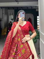 Load image into Gallery viewer, Red Tussar Silk Dhavani set includes a stitched lehenga made from tussar silk with Patola print, featuring a drawstring waist (fits up to 42) and zip closure. The lehenga has a 42-inch length with 3.8 meters of flair and a micro cotton inner lining. The unstitched blouse piece is tussar silk with printed design,

