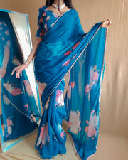  this light sky georgette saree, a perfect combination of elegance and comfort. Made from high-quality georgette fabric, this saree is lightweight, flowy, and ideal for both casual and formal occasions, adding a touch of sophistication to your wardrobe.
