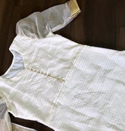 kurti is made from soft organza fabric with check patterns and a zari border. It features a pan neck and puff half sleeves, measuring 44 inches in length. Easy to care for with machine wash. Includes one kurti piece.